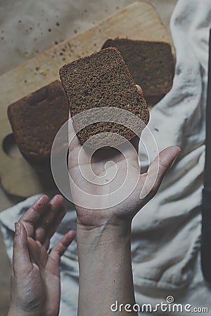 Food concept. Hand cutting bread. Slicing a bread. Top view Stock Photo