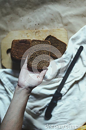 Food concept. Hand cutting bread. Slicing a bread. Top view Stock Photo