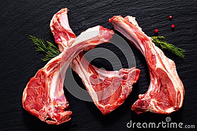 Food concept Organic lamb chops on black slate stone with herbal Stock Photo