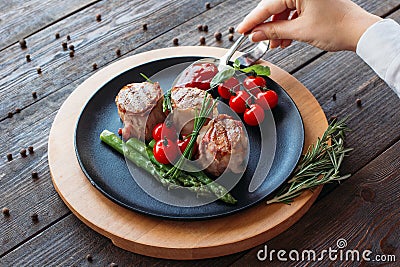 Food cooking. Chef decorating a pork dish. Stock Photo