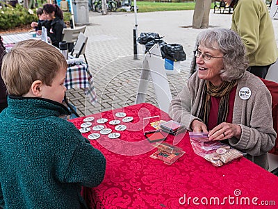 Food Day workers hands farmers market tokens to young boy Editorial Stock Photo