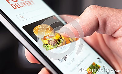 Food delivery app order with phone. Online mobile service for take away burger and pizza. Hungry man reading restaurant menu. Stock Photo