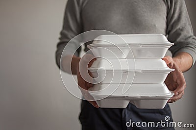 Food delivery. The courier man holding a container of food. Stock Photo