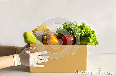 Food delivery. Food donation on table. Help cardboard box wiht various canned food, cereals, pasta and vegetables Stock Photo