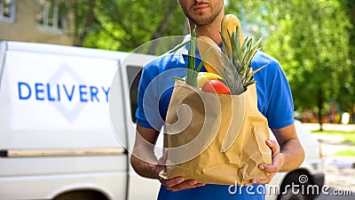 Food delivery service, male worker holding grocery bag, express food order Stock Photo