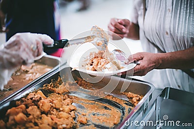 Food donation to hungry people, poor hands waiting to receive free food from volunteers Stock Photo