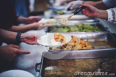 Food donation to hungry people, poor hands waiting to receive free food from volunteers Stock Photo