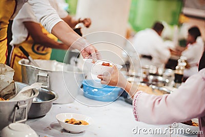 Food donation to the poor: The hands of the homeless are waiting to receive food from volunteers Stock Photo