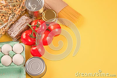 Food donations on yellow background with copy space - pasta, vegatables, canned food, cooking oil. Food bank and food Stock Photo