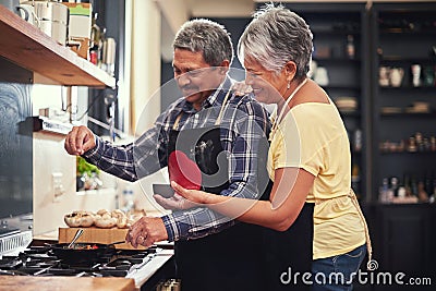 Food, happy senior couple cooking in kitchen and at their home. Collaboration or teamwork of partners, family or Stock Photo