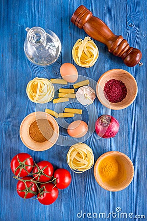 Food ingredients for Italian pasta on blue wooden desk background top view Stock Photo