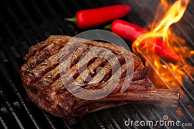 Food meat - beef steak on bbq barbecue grill with flame Stock Photo