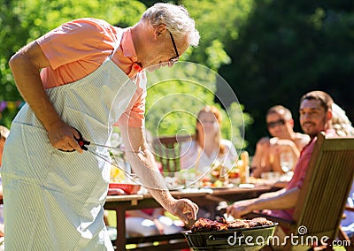 Senior man cooking meat on barbecue grill outdoors Stock Photo