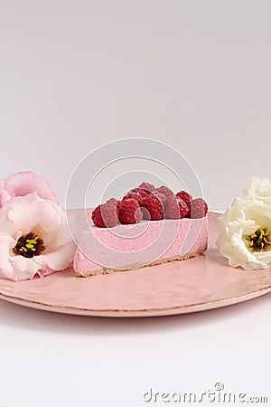 Cheesecake with raspberries and fresh flowers on a plate Stock Photo