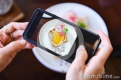 Food photography woman hands make photo cake with smartphone - taking photo food for post and share on social networks with camera Stock Photo