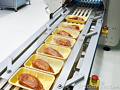 Food products meat chicken in plastic pack on conveyor Stock Photo