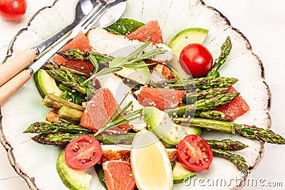 Food recipe background. Close up Asparagus salad grapefruit, cherry tomatoes, avocado, chicken fillet, spinach in bowl Stock Photo