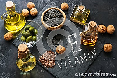 Food rich in vitamin E. A set of different oils. Seeds of flax, sunflower, walnut, olives. Top view. Stock Photo