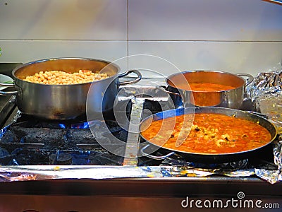 Food simmering in pots and pans in restaurant kitchen Stock Photo