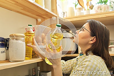 Food storage, woman taking food, sunflower oil for cooking Stock Photo