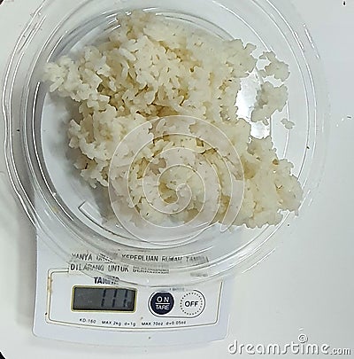 Food Weighing of white Rice using digital food scale Editorial Stock Photo