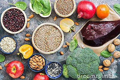 Foods high in iron. liver, broccoli, persimmon, apples, nuts, legumes, spinach, pomegranate. Top view, flat lay. Stock Photo