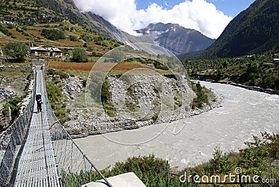 Foot-bridge over large river, trekking Nepal Stock Photo