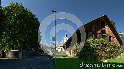 Swiss farmhouse and the Flums church of Saint Laurence Editorial Stock Photo