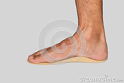 Foot on orthotics or orthopedic insole to support arch of flat feet on white background Stock Photo