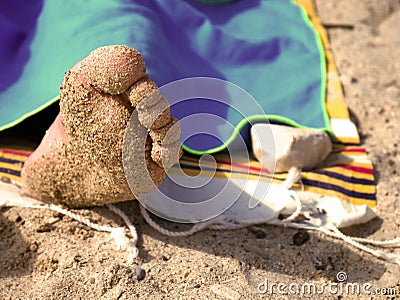 Foot in the sand during a sunny summer day at sea Stock Photo