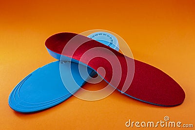 Foot support and healthy feet concept with orthopedic shoe insoles isolated on orange background Stock Photo