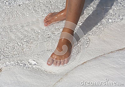 Foot in water natural travertine pools and terraces, cotton castle, Pamukkale, Turkey Stock Photo