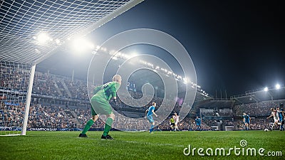 Football Championship: White Team Forward Hits the Ball and Scores Perfect Goal. Goalkeeper Jumps Stock Photo