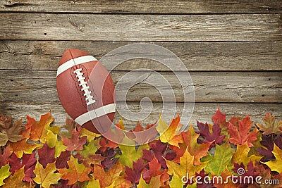 Football with fall leaves on rough wood top view Stock Photo