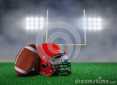 Football and Helmet on Field with Goal Post Stock Photo