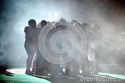 Football Huddle in fog Stock Photo