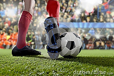 Football player in action running and dribbling at soccer stadium playing match Stock Photo