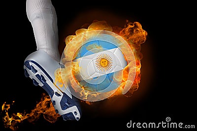 Football player kicking flaming argentina flag ball Stock Photo