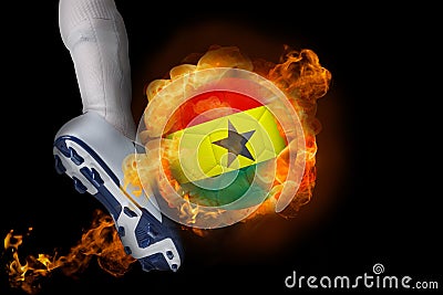 Football player kicking flaming ghana flag ball Stock Photo