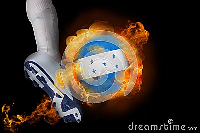 Football player kicking flaming honduras flag ball Stock Photo