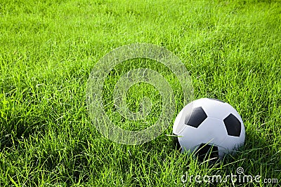 Football or soccer ball on the green field Stock Photo