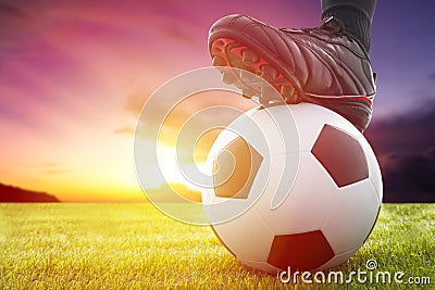 Football or soccer ball at the kickoff of a game with sunset Stock Photo
