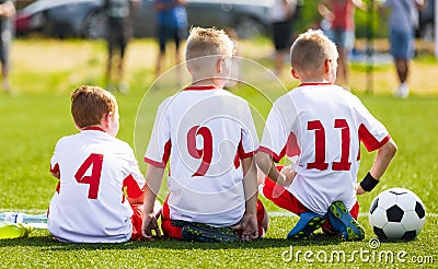 Football soccer game for children. Kids substitute players sitting on a bench. Editorial Stock Photo
