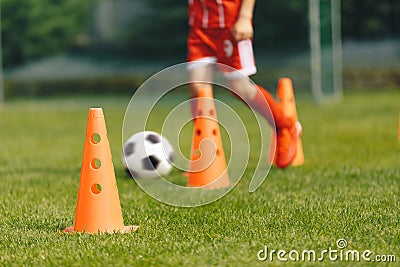 Football Training Background. Orange Practice Cone. Player Running Ball in Slalom Drill in Blurred Background Stock Photo