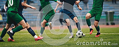 Footballers in action on the tournament game. Soccer football players competing for ball and kick ball during match in the stadium Stock Photo