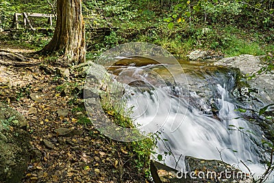 Footbridge and Falling Water Creek Editorial Stock Photo