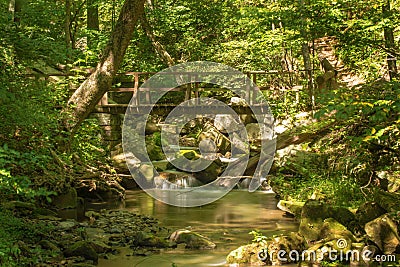 Footbridge over a Wild Mountain Trout Stream Stock Photo