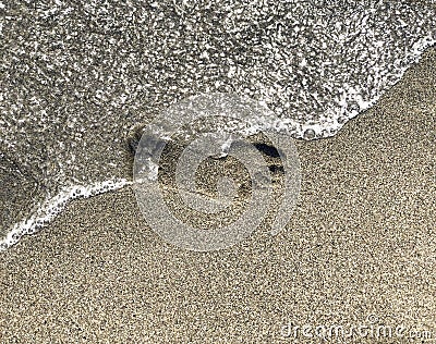 Footprint on sand washing out by sea wave close-up. People disappear concept Stock Photo
