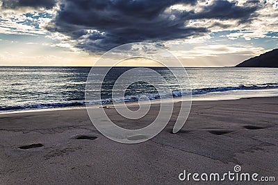 Footprints on sand and evening sea view at Makua beach, Oahu Stock Photo