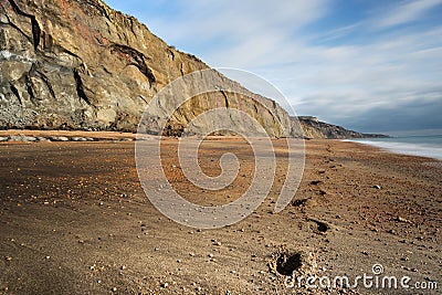 Footsteps lead along the deserted beach at Whale Chine in The Isle of Wight Stock Photo